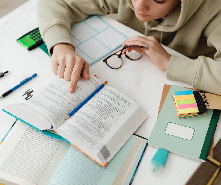 student studying with lots of books around them