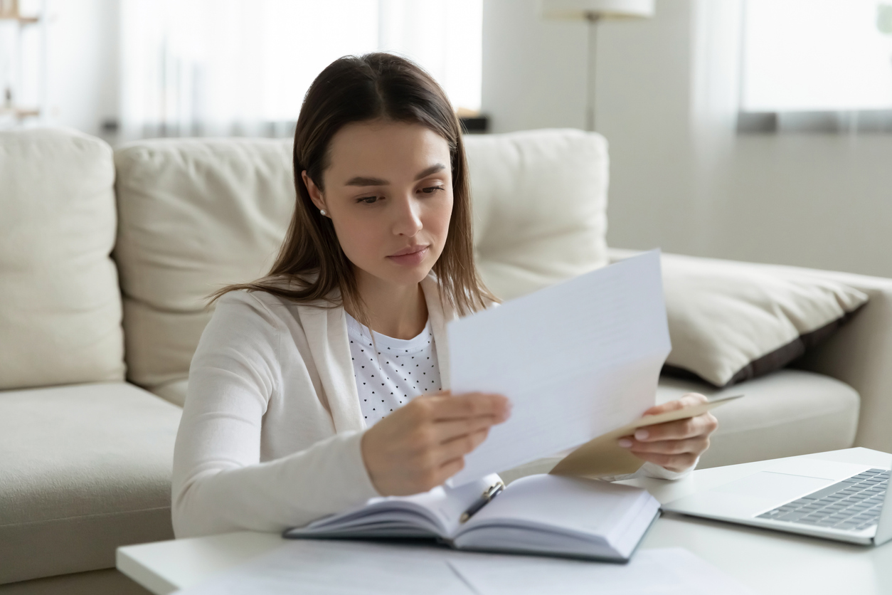 young woman looking at wage garnishment notice about her defaulted student loan