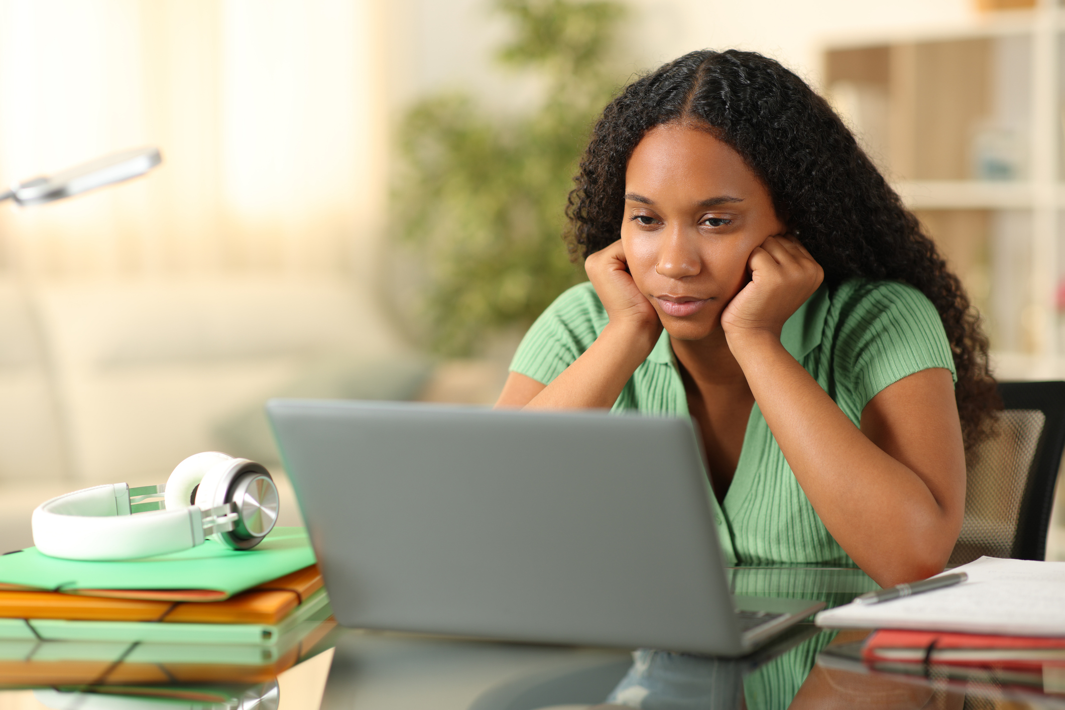 Disappointed teen looking at financial aid offer on laptop