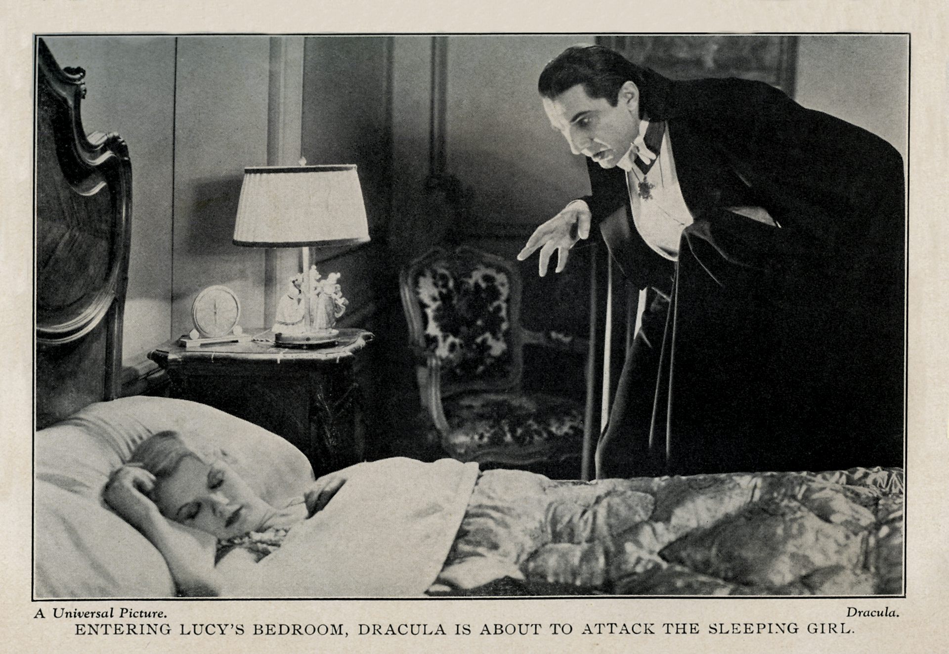 A black-and-white photo shows a woman lying in a bed sleeping, while a man wearing a black jacket and white shirt leers over her.
