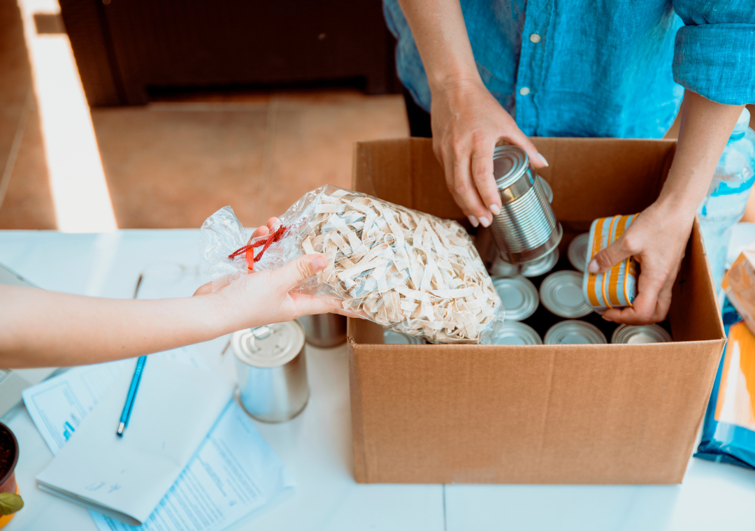 hands filling a food box at a food bank