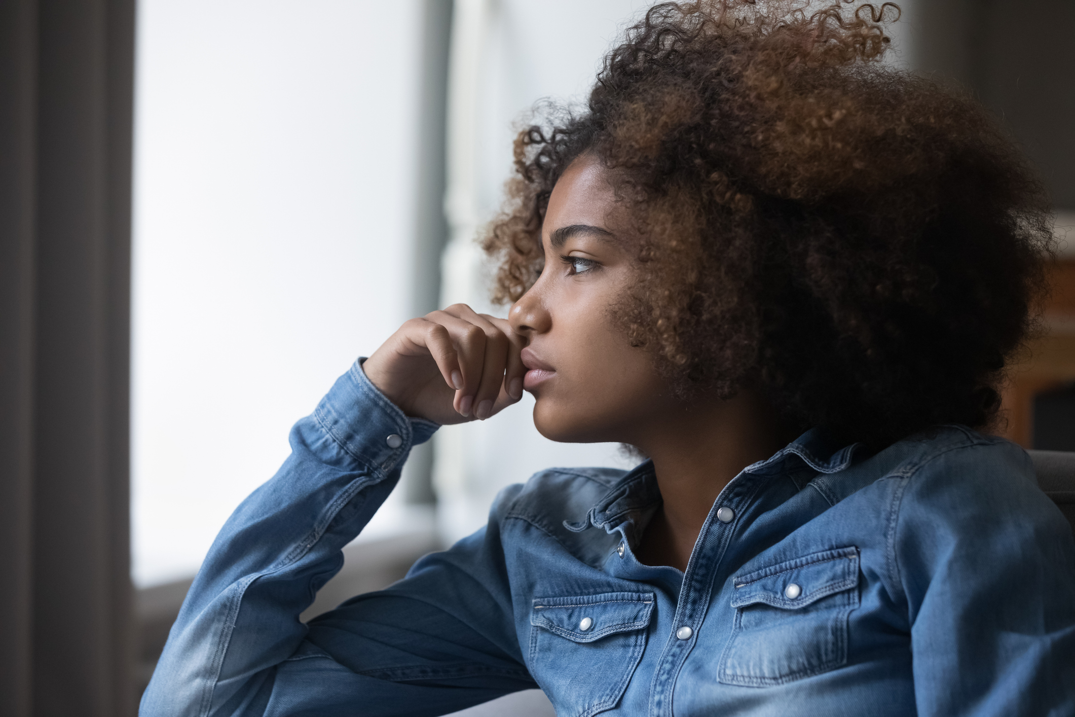 Closeup face African sad thoughtful teenager girl looking into distance