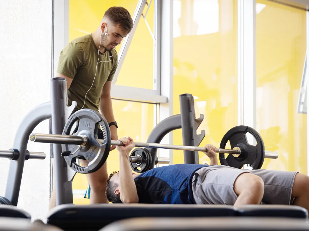 Two students using a weight rack at the gym