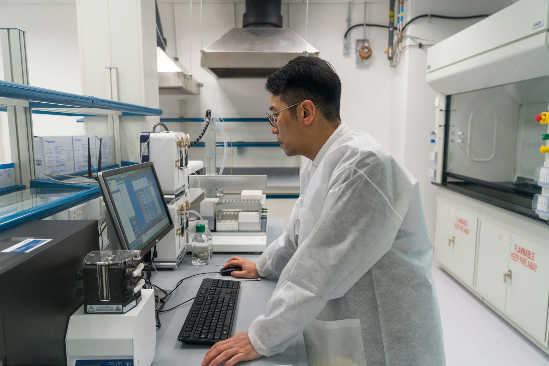 A biotech researcher working on a computer in a lab