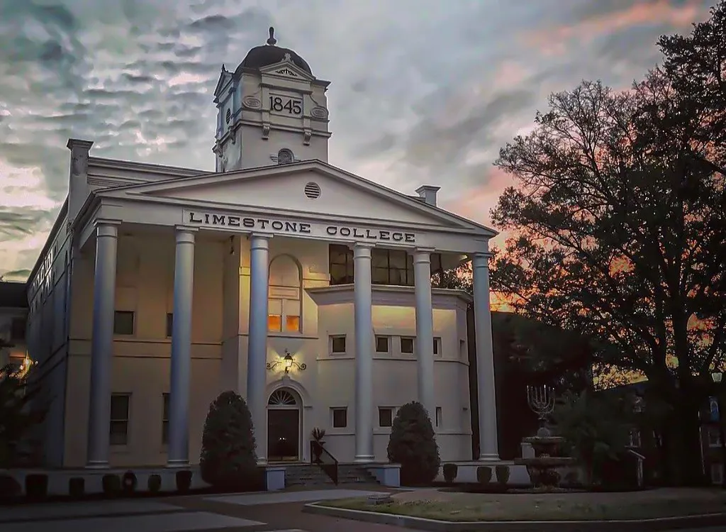 A white building with columns against the sunset.