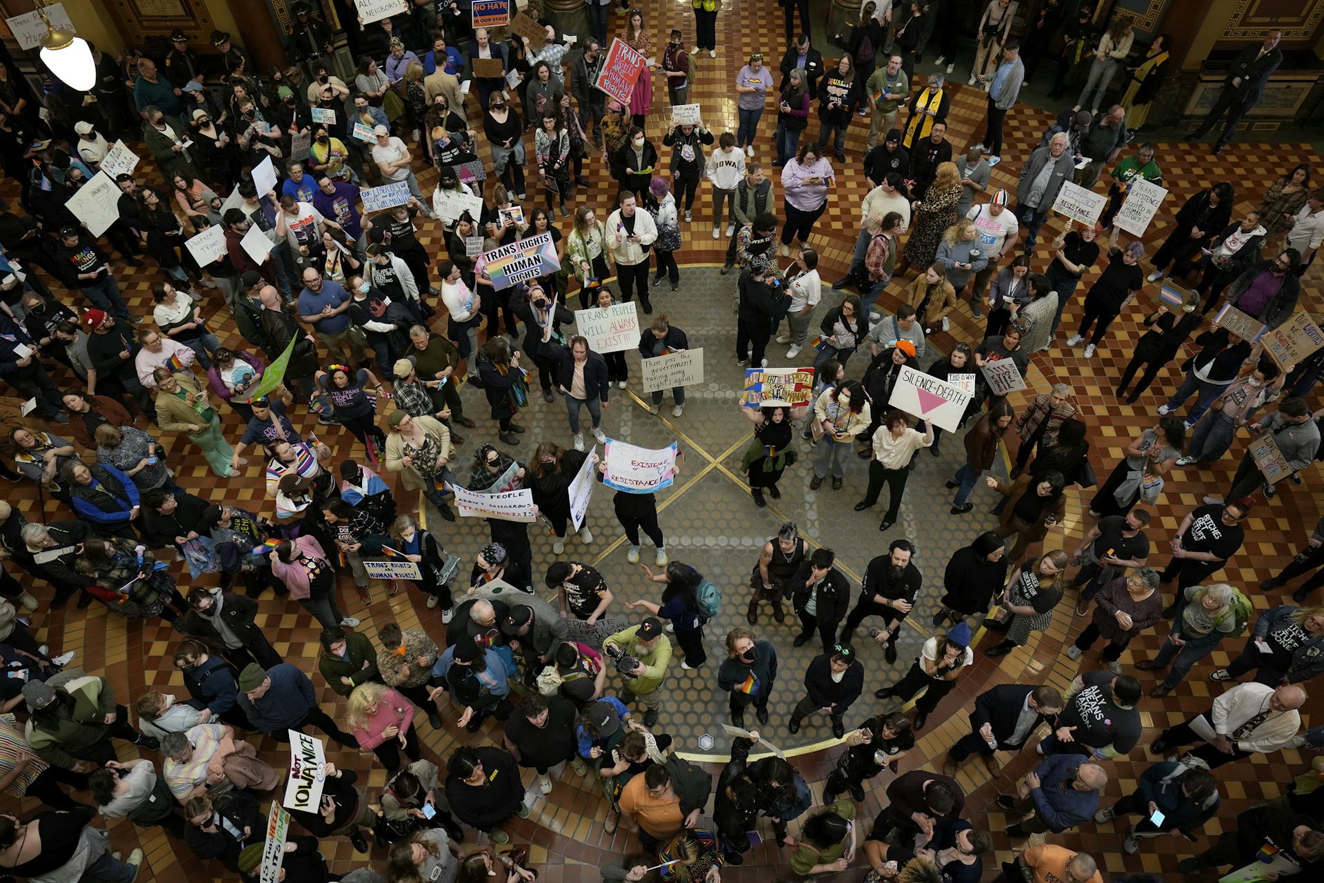 Crowd of protestors holding signs inside a capitol building