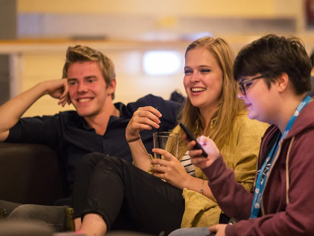 Three students watching TV together