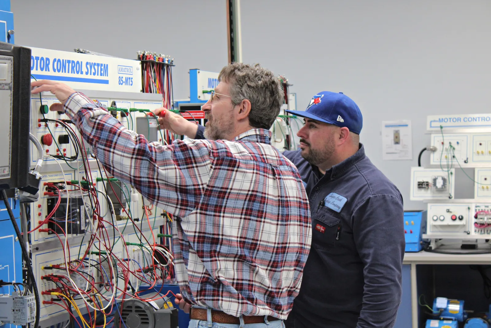 Two people stand next to machinery at Clark State College